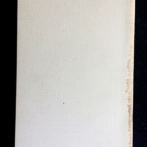 K&ouml;nnte beinhalten: Ein rechteckiges St&uuml;ck cremefarbenes Papier mit strukturierter Oberfl&auml;che. Der rechte Rand weist leichte Verf&auml;rbungen auf. Das Papier liegt vor einem dunklen Hintergrund.