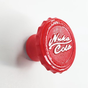 May include: Red bottle cap shaped knob with a white "Nuka Cola" logo.