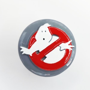 May include: A red circle with a white ghost inside and a diagonal line through it. The circle is on a grey background.