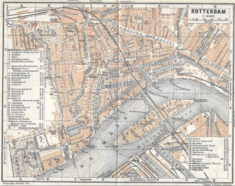 May include: A vintage map of Rotterdam, Netherlands, with a scale of 1:16,600. The map shows the city's streets, canals, and landmarks, including the Central Station and the Maas River.