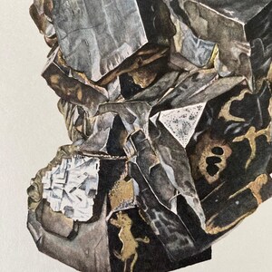 May include: A close-up of a dark gray and black mineral specimen with a rough, textured surface. The mineral has a crystalline structure and appears to be a type of galena.