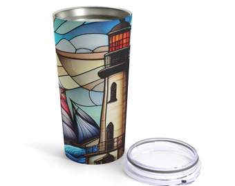 May include: A stainless steel tumbler with a colorful stained glass design featuring a lighthouse and a sailboat. The tumbler has a clear lid.