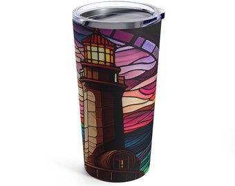 May include: A stainless steel tumbler with a colorful stained glass design of a lighthouse with a light shining from the top. The background is a sunset with pink, orange, and blue colors.