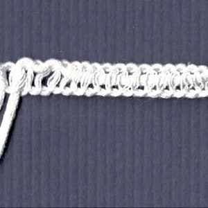 May include: White trim with two loops, a decorative trim for curtains or other home decor projects.
