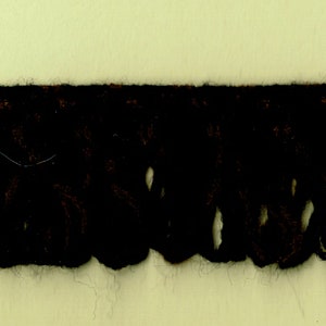 May include: Close-up of a brown fringe trim with a scalloped edge.