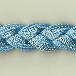 May include: A close-up of a braided light blue cord. The cord is made of a soft, silky material and has a subtle sheen.