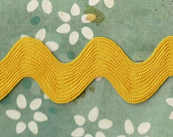 May include: A yellow zig-zag trim with a wavy pattern. The trim is made of a soft, textured fabric.