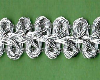 Puede incluir: Borde trenzada plateada con un diseño de bucle. La cinta tiene aproximadamente 1,2 cm de ancho.