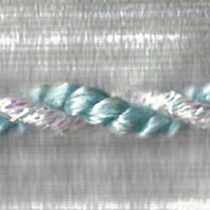 May include: A close-up of a light blue and white braided trim. The trim is made of a soft, delicate material and has a subtle sheen.