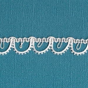 May include: White lace trim with a scalloped edge. The trim has a delicate, intricate design with small beads.