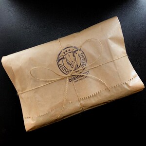 Kraft gift packaging with brand logo in the center and jute rope wrapping, available as gift option for the handmade leather journal.