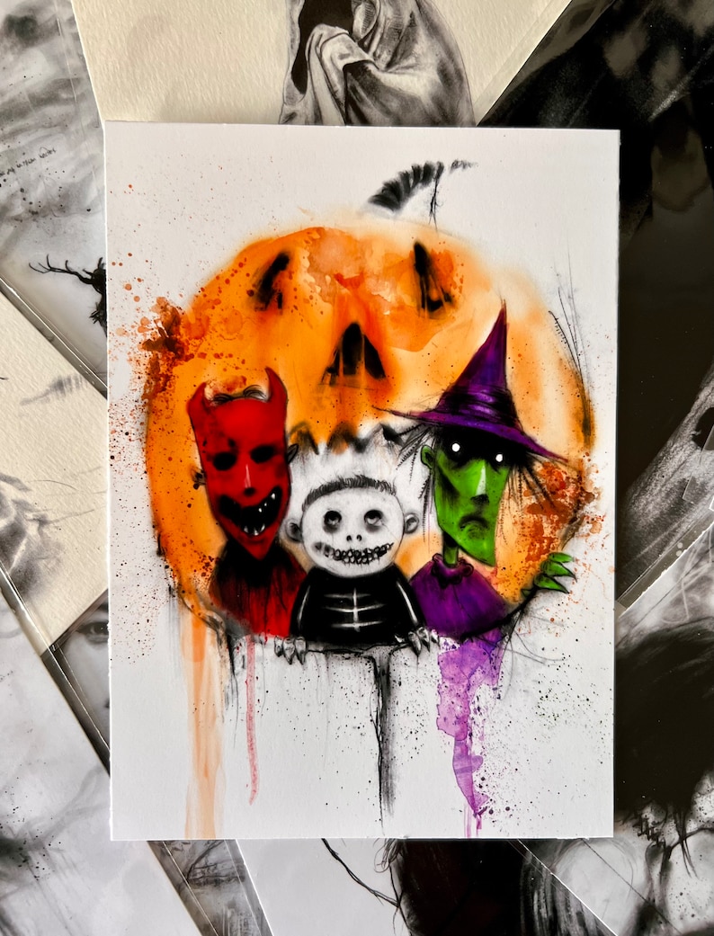 May include: Watercolour painting featuring three spooky characters in front of an orange pumpkin. The characters include a red devil, a skeleton, and a green witch. The artwork has a Halloween theme with paint splatters.