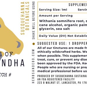Op de afbeelding: Een illustratie van een paardenkop in bruin en grijs met de tekst "Tincture of Ashwagandha" en "FL OZ BATCH #" eronder. Het etiket bevat ook de tekst "SUSQUEHANNA BOTANICALS" en "HERBSANDCBD.COM". Het product is een flesje van 30 ml Ashwagandha-tinctuur. Het etiket bevat ook voedingsinformatie en gebruiksaanwijzingen.