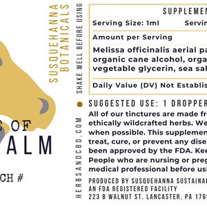 May include: A product label for Susquehanna Botanicals Tincture of Lemon Balm. The label features a stylized illustration of two horse heads in yellow and gray. Text includes supplement facts and usage instructions.
