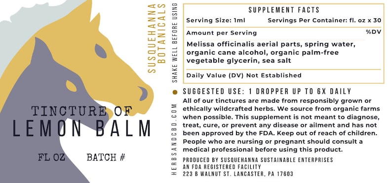 May include: A product label for Susquehanna Botanicals Tincture of Lemon Balm. The label features a stylized illustration of two horse heads in yellow and gray. Text includes supplement facts and usage instructions.
