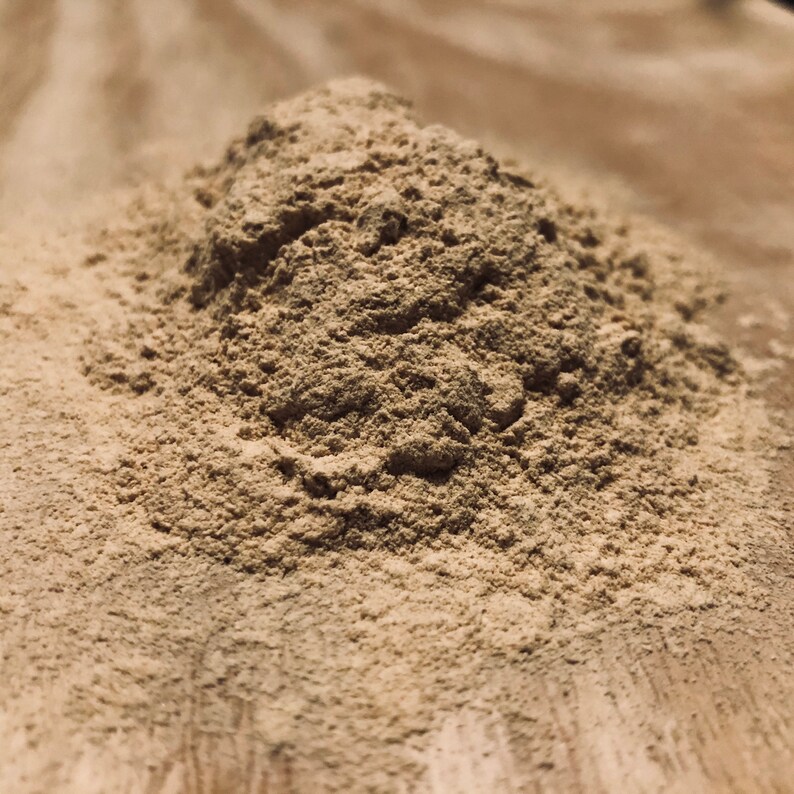 May include: A close-up of a pile of light brown powder on a wooden surface.
