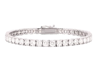 May include: A silver tennis bracelet with a row of round, clear gemstones. The bracelet is clasped and set against a white background. The gemstones are evenly spaced and reflect light.