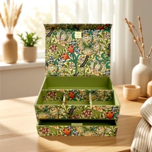 Peut inclure: Une boîte à bijoux rectangulaire ornée d'un motif floral vibrant avec des éléments botaniques verts, orange et bleus. La boîte possède un couvercle ouvert, un compartiment principal avec séparateurs et un tiroir coulissant, le tout doublé de vert.