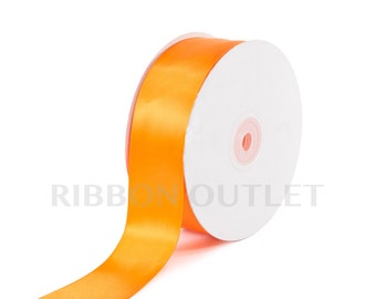 Pode incluir: Um rolo de fita de cetim laranja brilhante. A fita está desenrolando de um núcleo de papelão branco. O texto "RIBBON OUTLET" está impresso no carretel. A palavra "Orange" está impressa no canto inferior direito.