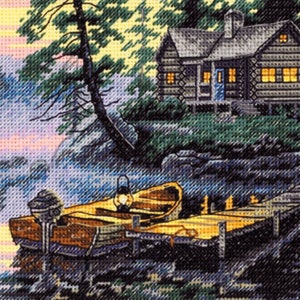 Könnte beinhalten: Kreuzstich-Landschaft eines Seehauses in der Abenddämmerung. Ein Holzsteg erstreckt sich in das Wasser, mit einem Boot und einer Laterne. Die Hütte hat beleuchtete Fenster und eine blaue Tür, umgeben von Bäumen und einem farbenfrohen Himmel.