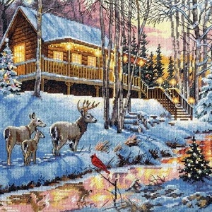 May include: A snowy winter scene with a cabin in the woods. The cabin has lights strung around the porch and a Christmas tree in front. There are deer in the snow and a cardinal perched on a branch.