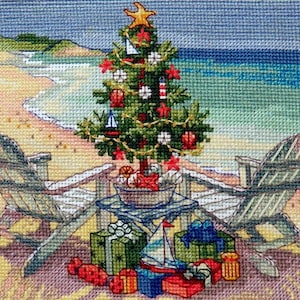 May include: A Christmas tree decorated with nautical ornaments, including sailboats, seashells, and starfish, is set up on a sandy beach with two beach chairs and presents underneath.