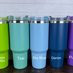 Op de afbeelding: Vijf roestvrijstalen bekers met deksels in verschillende kleuren: felgroen, teal, hemelsblauw, denimblauw en paars. De bekers zijn allemaal even groot en hebben dezelfde vorm.