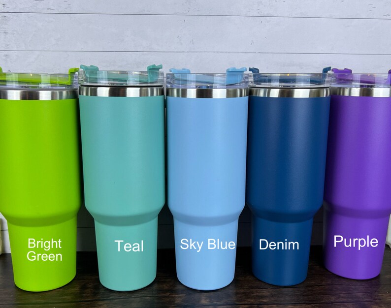 Op de afbeelding: Vijf roestvrijstalen bekers met deksels in verschillende kleuren: felgroen, teal, hemelsblauw, denimblauw en paars. De bekers zijn allemaal even groot en hebben dezelfde vorm.