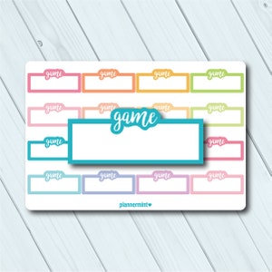 May include: A sheet of colorful planner stickers with the word "game" in various colors and styles. The stickers are rectangular with a tab at the top, perfect for organizing and labeling. The word "game" is also featured in a larger, teal-colored sticker.