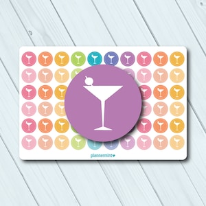 Könnte beinhalten: Ein Bogen mit bunten Aufklebern mit einem Cocktailglas-Design. Die Aufkleber sind in einem Rastermuster angeordnet, mit einem großen, zentralen Aufkleber eines Martinis in einem lila Kreis. Der Hintergrund ist ein helles Holzmaserung.