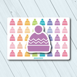 May include: A sheet of colorful winter hat stickers in various shades of pink, orange, yellow, green, blue, and purple. A larger, purple hat sticker with a white zig-zag design is in the foreground. The text "plannermint" is at the bottom.
