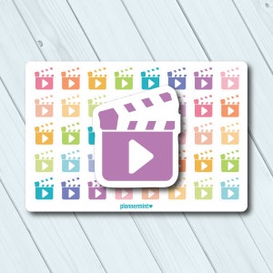 May include: A sheet of planner stickers featuring a repeating pattern of colorful film clapperboard icons. A large purple clapperboard sticker with a white play button is centered on the sheet. The text "plannermint" is at the bottom.