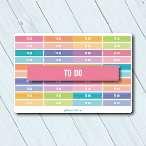 May include: A sticker sheet with a grid of colorful boxes, each labeled "TO DO." The boxes are in shades of pink, orange, blue, purple, green, and yellow. A pink banner across the center also reads "TO DO."