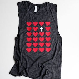 K&ouml;nnte beinhalten: Ein dunkelgraues &auml;rmelloses Tanktop mit einem Muster aus roten Herzen und einem wei&szlig;en Kreuz in der Mitte.