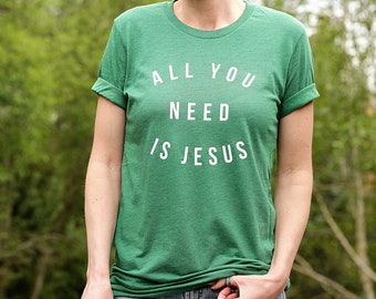 May include: Green t-shirt with white text that reads "All You Need Is Jesus".
