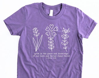May include: Purple short-sleeved t-shirt with a white graphic of three flowers and the text "grow in the grace and knowledge of our Lord and Savior Jesus Christ 2 Peter 3:10".