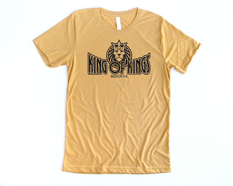 May include: A mustard yellow t-shirt with a black graphic of a lion wearing a crown and the text "KING OF KINGS" with the scripture reference "REVELATION 19:16".