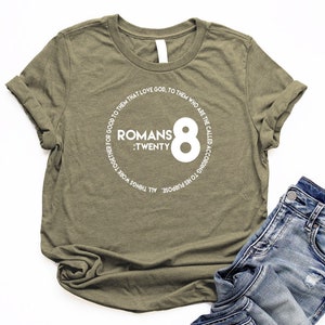 May include: A green t-shirt with a white circle graphic that says "Romans 8:Twenty" and "All things work together for good to them that love God. To them who are the called according to His purpose."