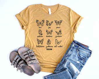 May include: Mustard yellow t-shirt with black butterfly graphics and the text "love, joy, peace, patience, kindness, goodness, faithfulness, gentleness, self-control, Galatians 5".