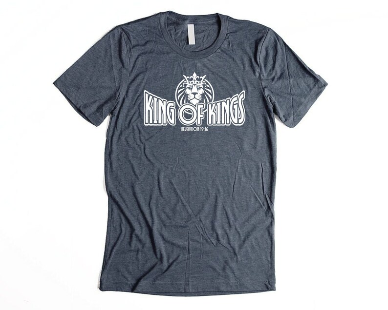 May include: A dark blue t-shirt with a white graphic of a lion wearing a crown and the text "King of Kings" with the words "Revelation 19:16" underneath.