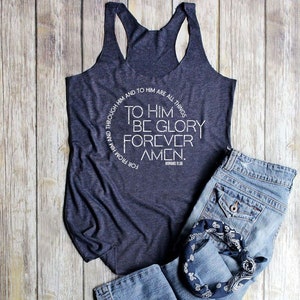 May include: A navy blue tank top with a white circle graphic featuring the text "To Him Be Glory Forever Amen."  The text is in a circular design with the words "For From Him And Through Him And To Him Are All Things" surrounding the main text.  The text "Romans 11:36" is also included in the graphic.