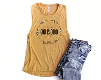 May include: Mustard yellow sleeveless tank top with a black and white graphic print that reads "all the time GOD IS GOOD all the time LUKE 18:19".