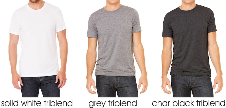 May include: Three men's t-shirts in different colors: solid white, grey, and charcoal black. All shirts are triblend.