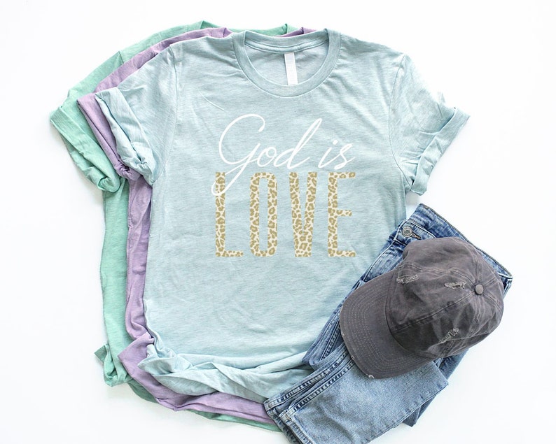 May include: A light blue t-shirt with the text "God is Love" in white lettering. The word "Love" is in a leopard print pattern.