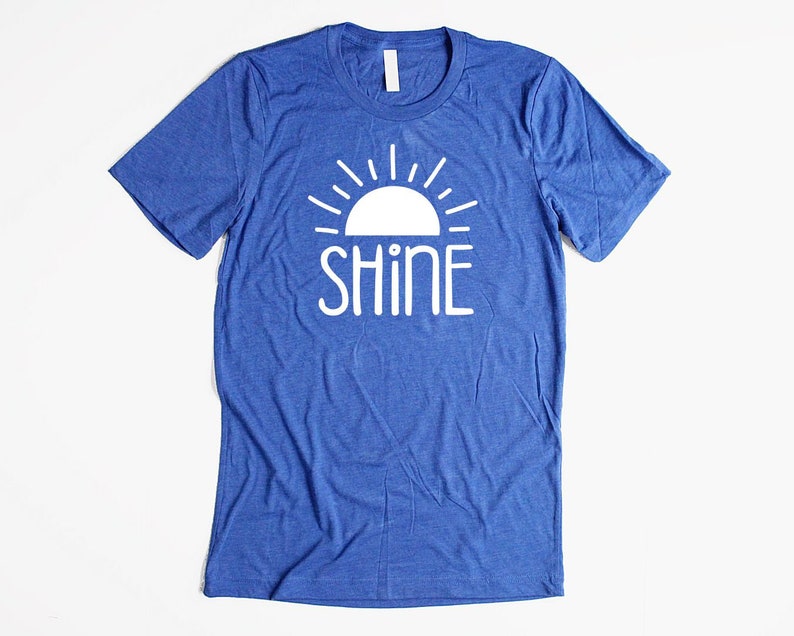 May include: A blue t-shirt with a white sun and the word "SHINE" printed on the front.