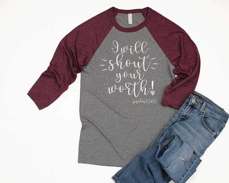 May include: A gray and burgundy raglan t-shirt with the text "I will shout your worth! Psalm 139:13" printed in white on the front.