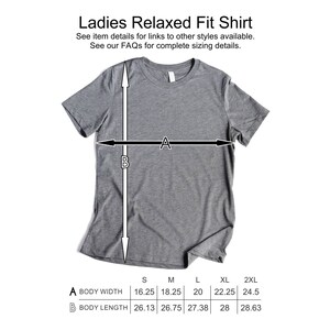 May include: A gray relaxed fit t-shirt with measurements for different sizes. The measurements are labeled "Body Width" and "Body Length" and are in inches. Sizes include S, M, L, XL, and 2XL.