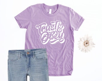 Trust & Obey Christian Shirt for Girls with Isaiah 50:10 Bible Verse featuring lyrics from the classic Sunday School Song about Jesus