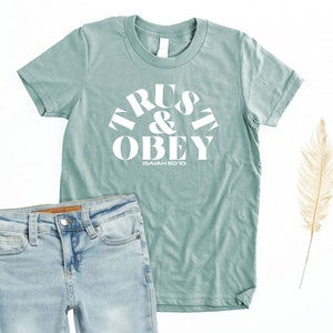 Trust & Obey Christian Shirt for Girls with Isaiah 50:10 Bible Verse featuring lyrics from the classic Sunday School Song about Jesus
