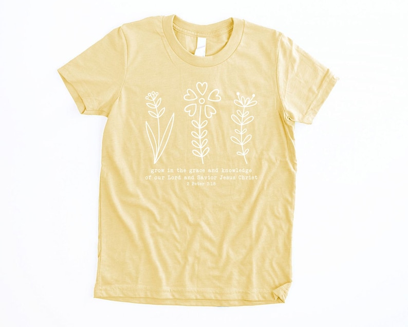 May include: A yellow t-shirt with a white floral design and the text "grow in the grace and knowledge of our Lord and Savior Jesus Christ 2 Peter 3:18".